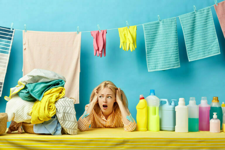 scred surprised housewife holding her head, girl is afraid of dirty clothes